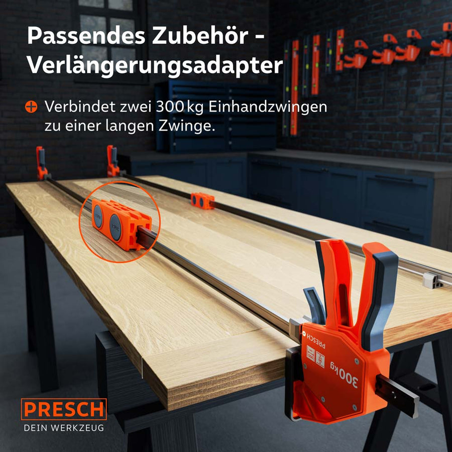 Innovatie voor overlengtes: Een oranje verlengadapter verbindt de rails van twee 300kg eenhandklemmen tot een extreem lange klem, om zelfs de breedste lijmhoutplaten moeiteloos te spannen.