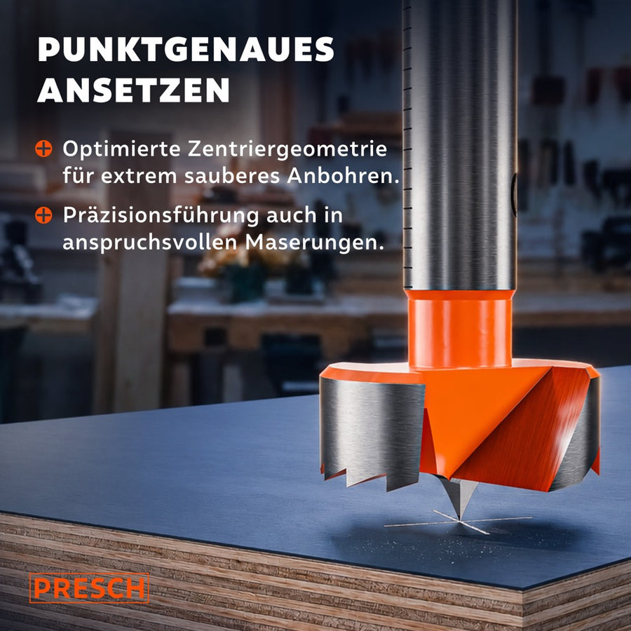 Zentrierspitze des Forstnerbohrers setzt punktgenau auf einer Spanplatte an.