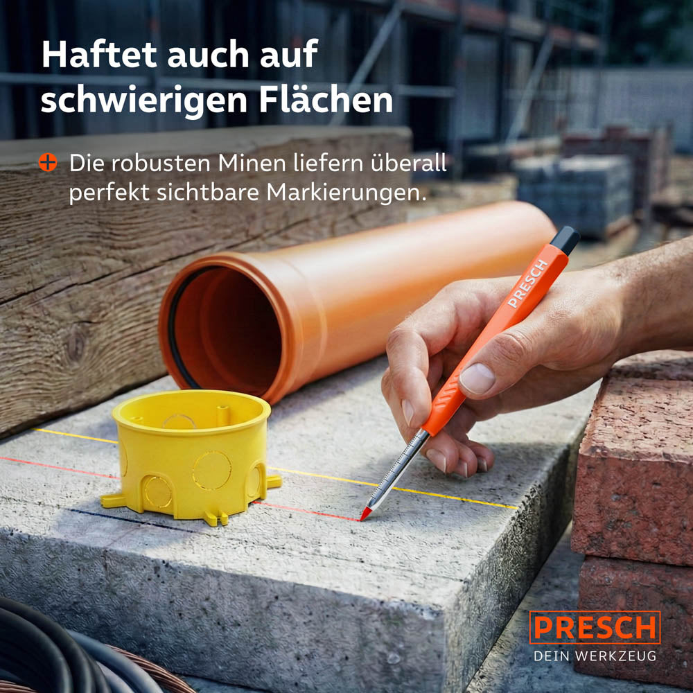 Markieren auf schwierigen Flächen: Der Marker zeigt rote und gelbe Linien auf einer Betonplatte neben Baustellenzubehör wie Rohren und Ziegeln.