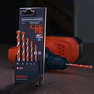 PRESCH Profi Universalbohrer Set mit verschiedenen Größen im Vordergrund und Bohrmaschine im Hintergrund auf Holzoberfläche.