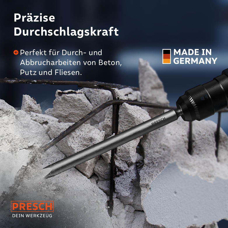 Die Spitze des Meißels durchbricht Betonschutt mit freigelegter Armierung im praktischen Einsatz.