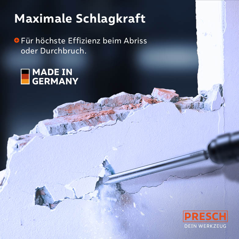 Der Spitzmeißel durchbricht eine verputzte Wand und legt das dahinterliegende Mauerwerk frei.