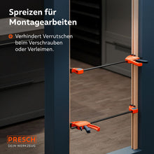 Montagebeispiel im Innenausbau: Zwei Zwingen werden im Spreizmodus eingesetzt, um eine Türzarge während des Einbaus stabil und exakt auf Distanz zu halten.