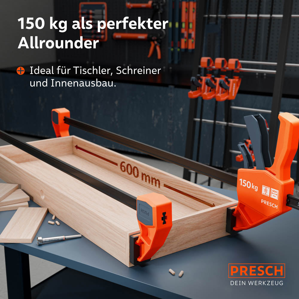 Anwendungsbeispiel bei langen Werkstücken: Zwei 600mm Einhandzwingen fixieren eine breite Holzkonstruktion auf einer Werkbank während des Verleimens; perfekt für Tischler und Schreiner.