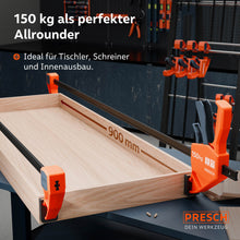 Anwendungsbeispiel bei sehr langen Werkstücken: Zwei 900mm Einhandzwingen fixieren eine große Rahmenkonstruktion aus Holz auf einer Werkbank; unverzichtbar für Tischler, Schreiner und den Innenausbau.