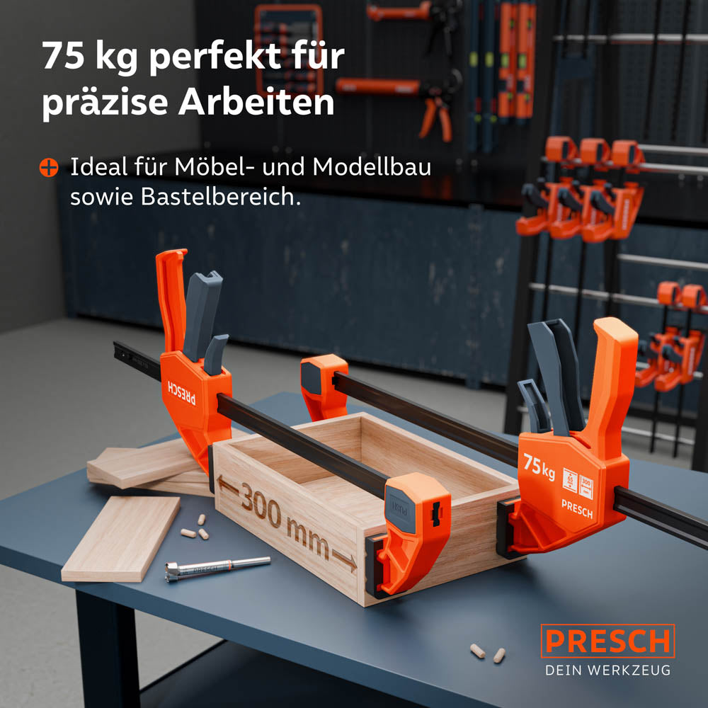 Anwendungsbeispiel: Zwei 300mm Einhandzwingen fixieren eine Holzbox auf einer Werkbank während der Montage; ideal für Möbelbau und DIY-Projekte.