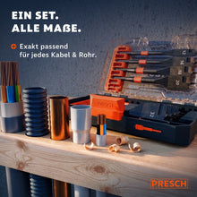 PRESCH Flachfräsbohrer Set in offener Aufbewahrungsbox auf einer Werkbank, daneben verschiedene Kabel, Rohre und Wellschläuche in unterschiedlichen Durchmessern