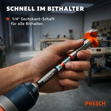 Hand hält den Forstnerbohrer mit Sechskantschaft vor einem Bithalter in der Werkstatt.