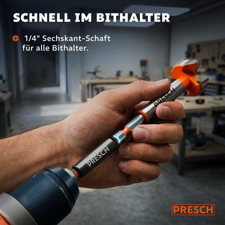 Hand hält den Forstnerbohrer mit Sechskantschaft vor einem Bithalter in der Werkstatt.