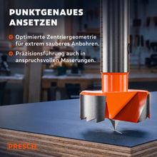 Zentrierspitze des Forstnerbohrers setzt punktgenau auf einer Spanplatte an.
