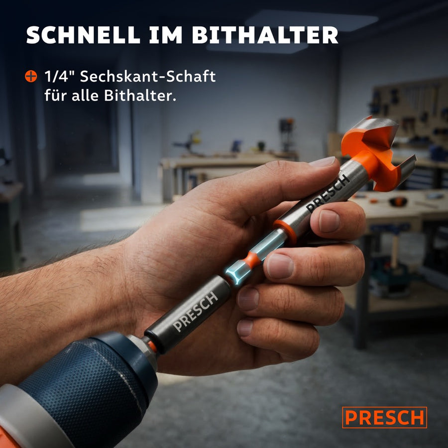 Hand hält den Forstnerbohrer mit Sechskantschaft vor einem Bithalter in der Werkstatt.