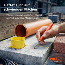 Markieren auf schwierigen Flächen: Der Marker zeigt rote und gelbe Linien auf einer Betonplatte neben Baustellenzubehör wie Rohren und Ziegeln.
