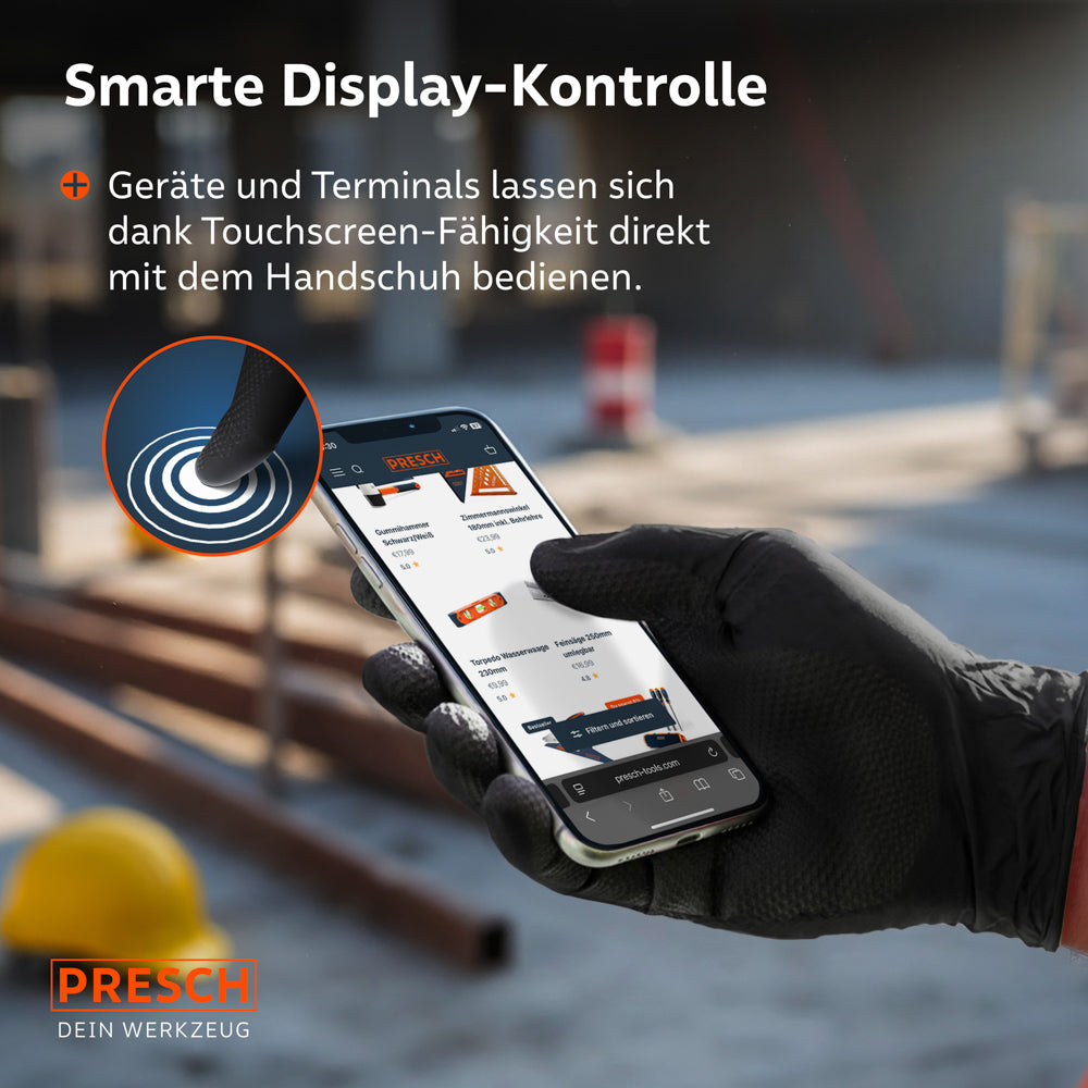 Touchscreen-Funktion: Ein Smartphone wird auf einer Baustelle direkt mit den schwarzen Heavy Duty Nitrilhandschuhen bedient.