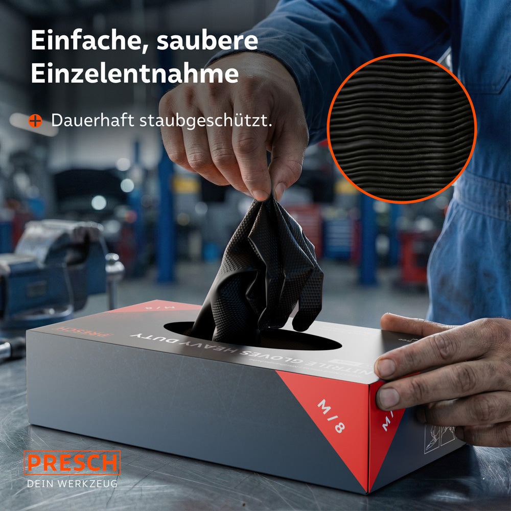 Entnahme eines schwarzen Heavy Duty Handschuhs aus der staubgeschützten Spenderbox in einer Werkstatt-Umgebung.