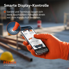 Slimme displaybediening: Bediening van een smartphone met oranje touchscreen-compatibele werkhandschoenen op een bouwplaats.