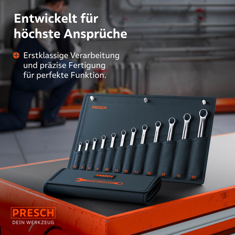 Die Rolltasche mit dem 12-teiligen Set liegt auf einem roten Werkstattwagen. Im Hintergrund arbeitet ein Mechaniker in einer Industriehalle, was den professionellen Einsatzbereich unterstreicht.