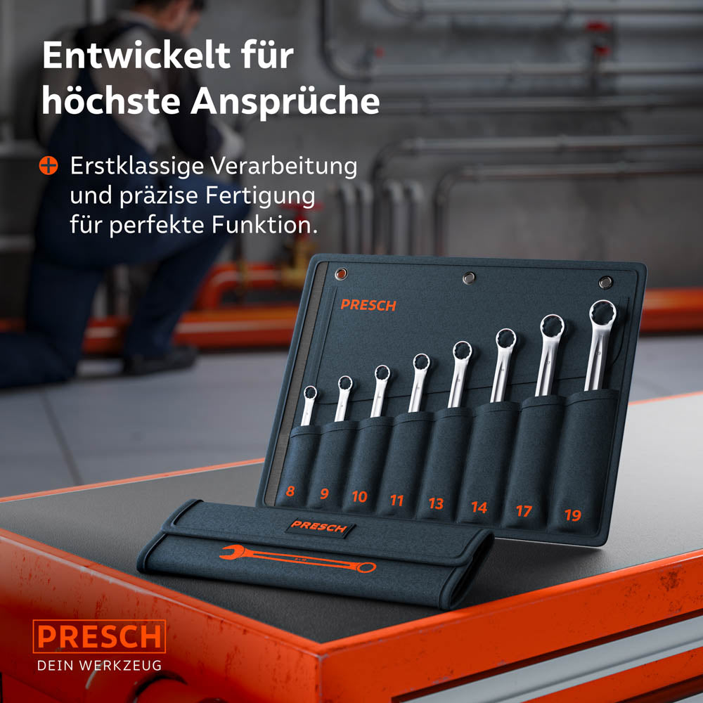 La sacoche à roulettes avec le set de 8 pièces repose sur un chariot d'atelier. En arrière‑plan, un mécanicien travaille sur une installation industrielle, ce qui souligne l’orientation professionnelle de l’outil.
