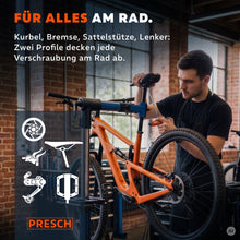 Monteur schroeft met een T-greep sleutel aan een mountainbike in de montagestandaard