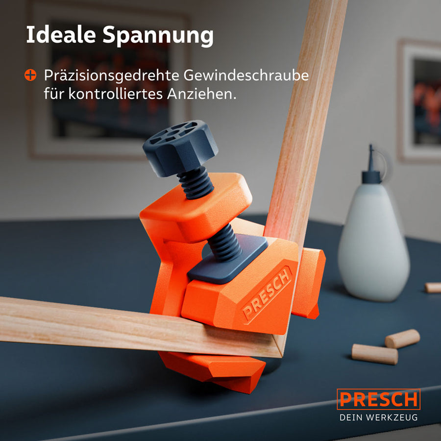 Detailansicht: Ein Winkelspanner fixiert zwei auf Gehrung geschnittene Holzleisten. Die präzisionsgedrehte Gewindeschraube mit ergonomischem Griff ermöglicht ein kontrolliertes Anziehen beim Verleimen.
