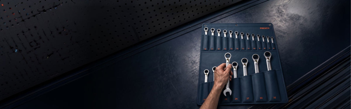 Hand nimmt einen PRESCH Ratschenschlüssel aus der Rolltasche des 20-teiligen Sets