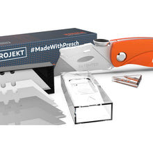Faltbares Teppichmesser von Presch mit Ersatzklingen und Sicherheitsverriegelung auf weißem Hintergrund. Cutter, Universalmesser.