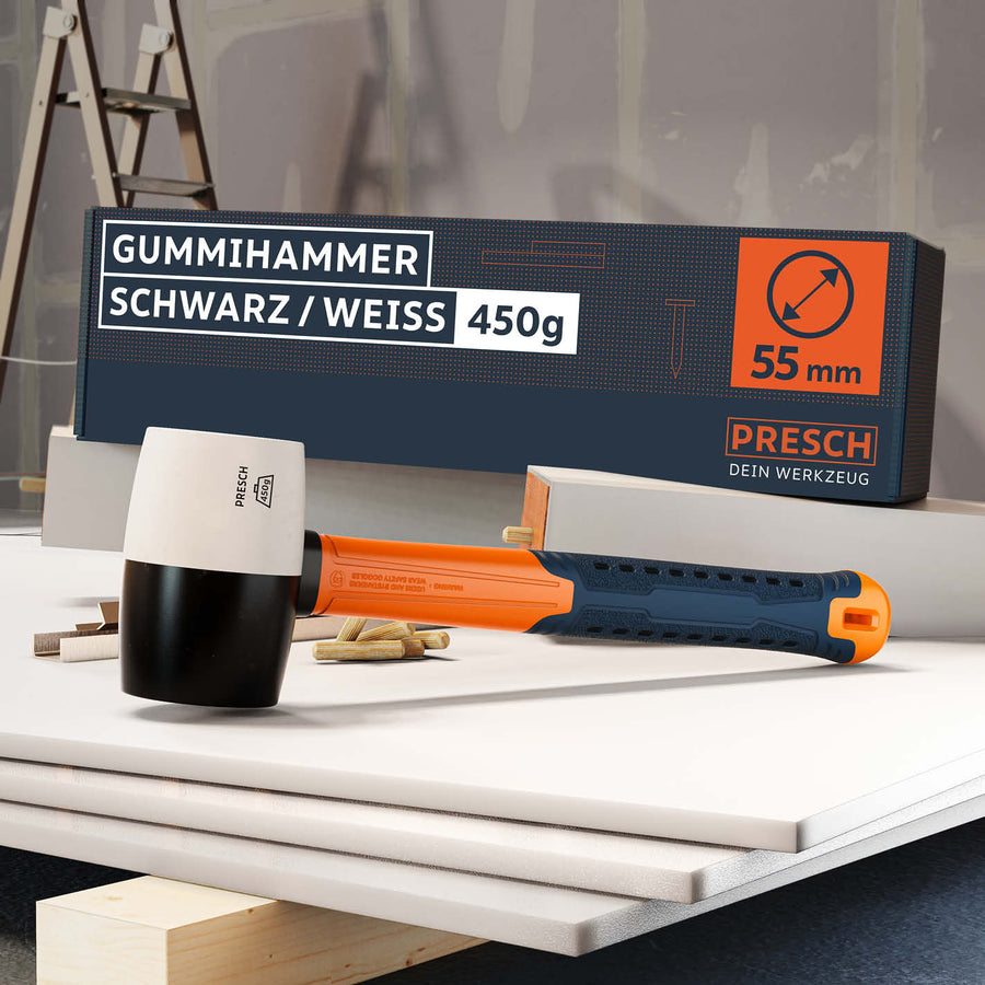 Tweekleurige Presch rubberen hamer in zwart en wit met ergonomische handgreep en 450g gewicht op werkbank