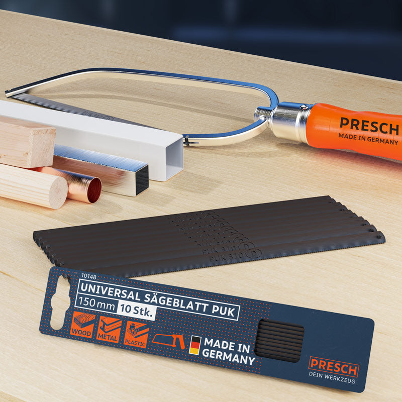 Universal Sägeblatt von PRESCH auf Arbeitsplatte neben weiteren Handwerkzeugen, Zugsäge und Metallsägeblatt als Zubehör.